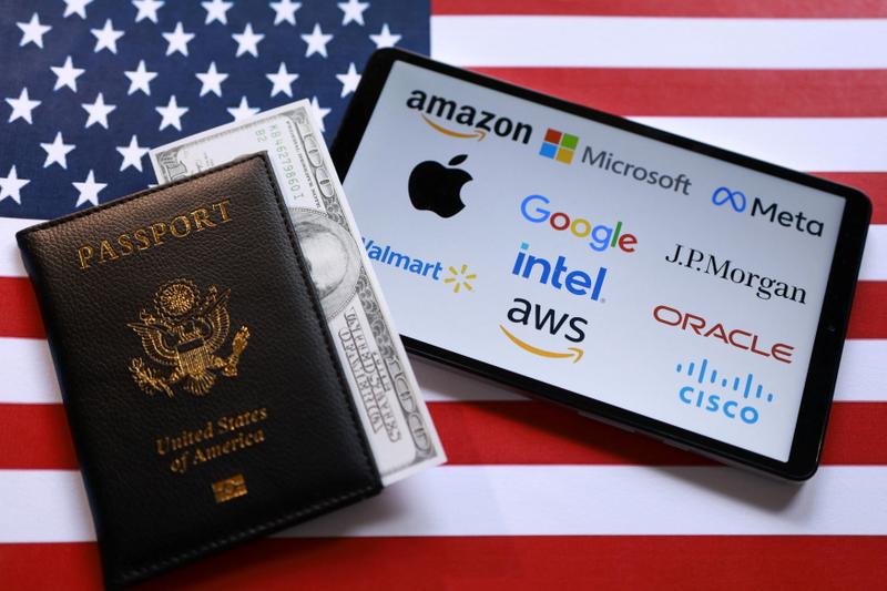 U.S. flag, mock passport, banknote, H-1B Visa application form and displayed company logos are seen in this illustration taken September 26, 2025. REUTERS/Dado Ruvic/Illustration